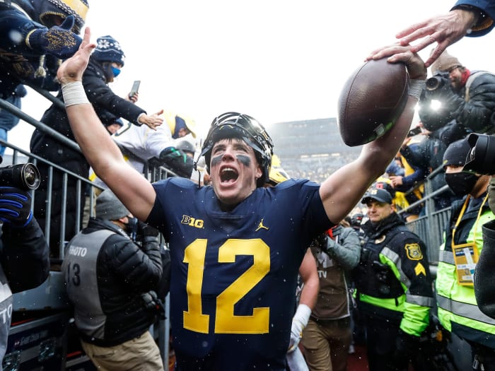 Michigan QB Cade McNamara celebrates the win over Ohio State with fans